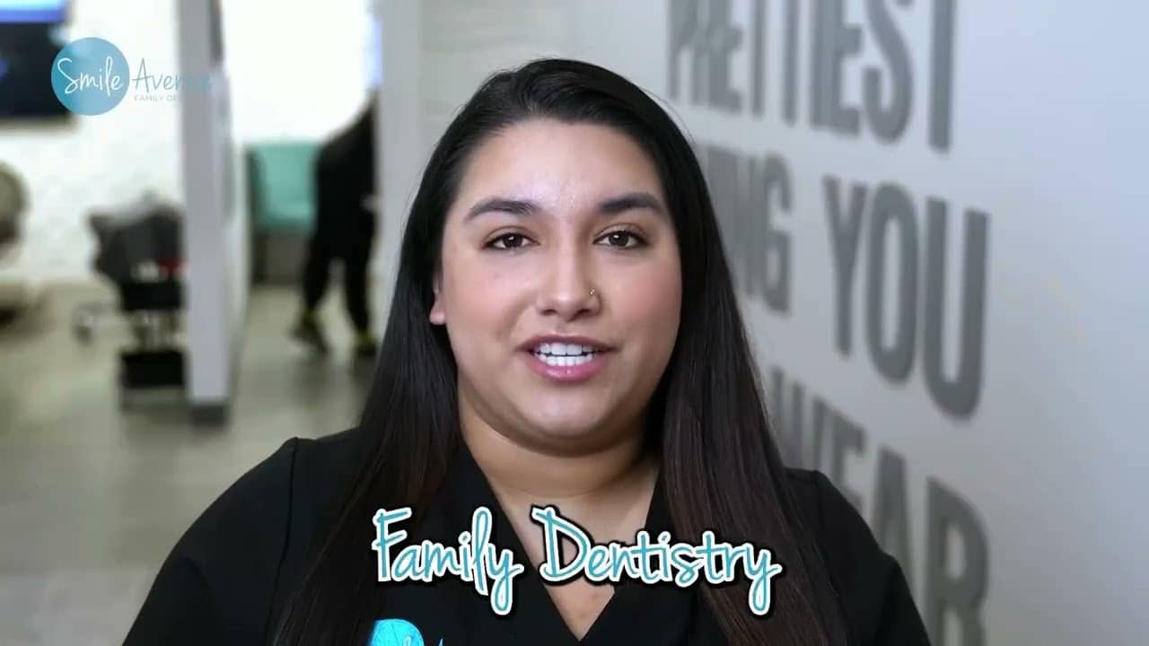 Confident woman with a welcoming smile in a dental clinic, representing oral health transformation through dental implants, highlighting the importance of smile aesthetics and jawbone integrity for post-surgery care.