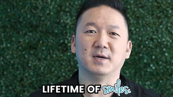 A dental professional speaking in front of a green leafy background with text overlay 'LIFETIME OF smiles.' on the image. Part of Katy Dental's video library focused on patient education and smile tips.