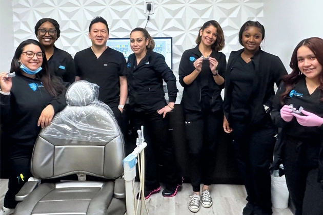 Dental team at Smile Avenue in Katy, TX posing in a modern dental office with equipment, showcasing expert family and cosmetic dentistry services.