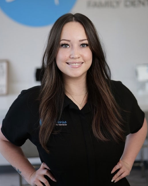 Smiling dental professional at Comprehensive Family Dentistry in Cypress and Katy, TX 2025, wearing a black uniform, standing confidently with hands on hips inside a modern dental office.