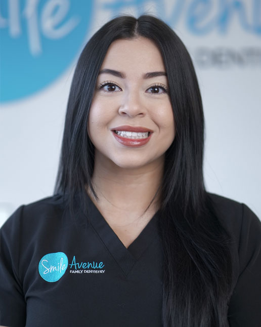 A smiling woman in a dental uniform with 'Smile Avenue Family Dentistry' logo, showcasing comprehensive family dentistry services in Cypress and Katy, TX.