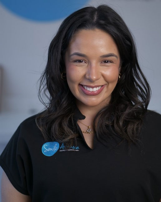 Smiling dentist in a 'Smile Avenue Family Dentistry' uniform, representing comprehensive family dentistry services in Cypress and Katy, TX, 2025.