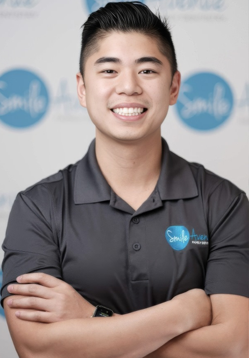 A smiling dental professional in a polo shirt with a 'Smile Avenue Family Dentistry' logo, representing comprehensive family dentistry services in Cypress and Katy, TX.