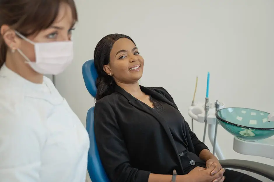 Patient smiling in a dental chair with a hygienist wearing a mask nearby at a family dentist in Cypress, TX. Dental care and cosmetic dentistry setting.
