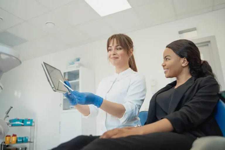 Dentist Showing A Patient Something On A Tablet In A Modern Dental Office, Highlighting Family And Emergency Dental Care Services In Cypress And Katy.