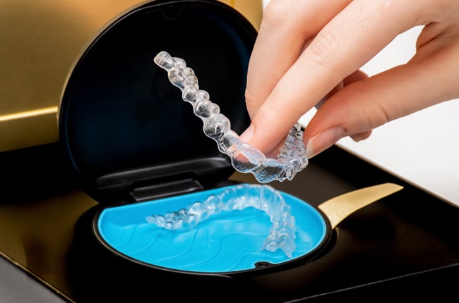 Invisalign Aligners1 6 Hands Holding A Clear Invisalign Aligner Tray